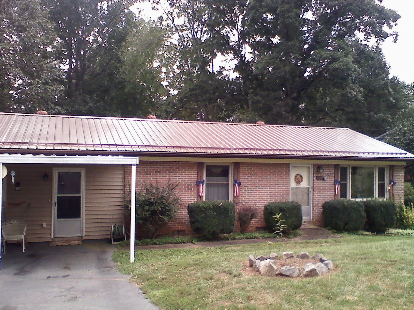 Bronze metal roof and carport on a brick ranch home — Roof Repair work by our crew in Polkville